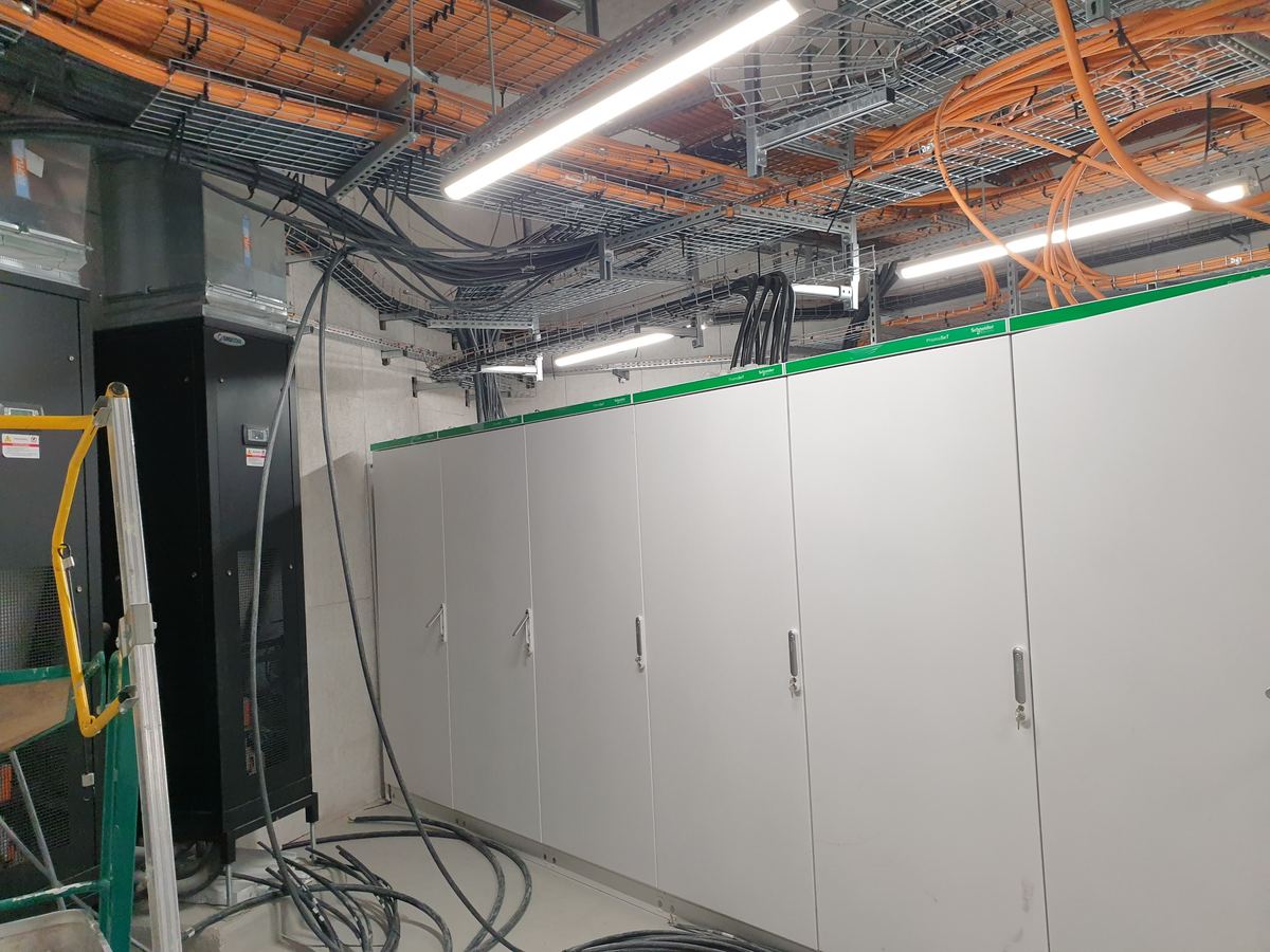 Salle technique électrique en cours d'installation, chemins de câbles et armoires